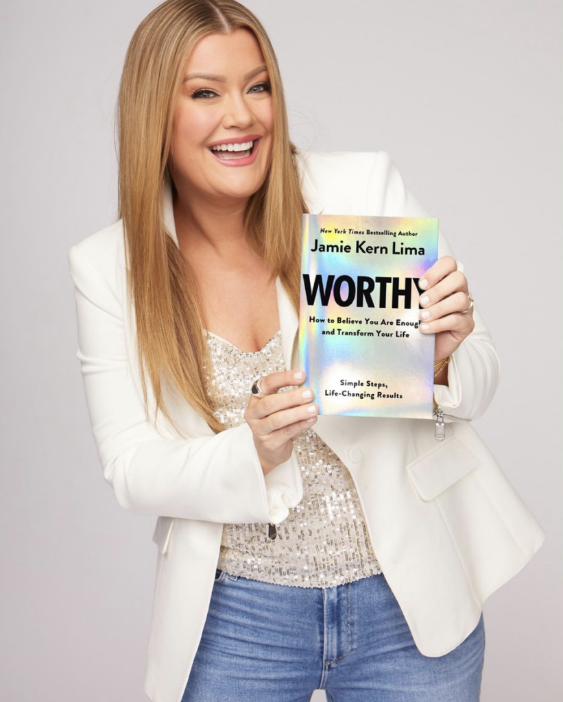 Jamie Kern Lima holding her new book "Worthy". Self-worth.